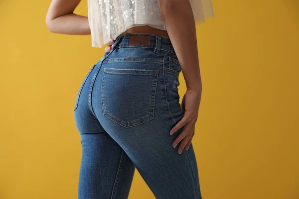Woman wearing jeans on yellow background, closeup — ストック写真
