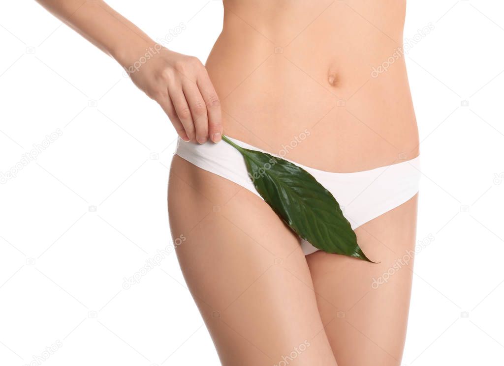 Woman with leaf showing smooth skin after bikini epilation on white background, closeup. Body care concept