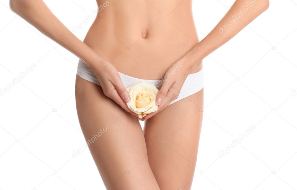 Woman with flower showing smooth skin after bikini epilation on white background, closeup. Body care concept
