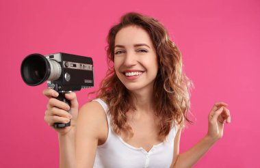Crimson Backg 'de eski model video kameralı güzel genç bir kadın.