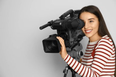 Beyaz arkaplanda profesyonel video kamerası olan operatör