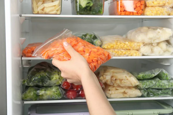 Woman Putting Plastic Bag Carrot Refrigerator Frozen Vegetables Closeup — Stock Photo, Image