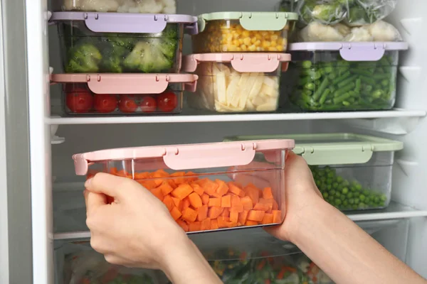 Mujer Poniendo Recipiente Con Zanahoria Refrigerador Con Verduras Congeladas Primer —  Fotos de Stock