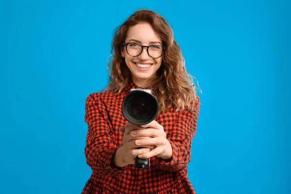 Krásná mladá žena s vintage video kamera proti světlu bl — Stock fotografie