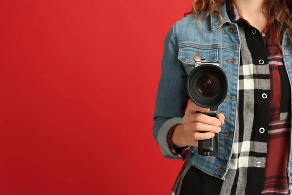 Mulher com câmera de vídeo vintage no fundo vermelho, close-up. Espada. — Fotografia de Stock