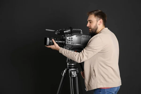 Operator with professional video camera on black background — Stock Photo, Image