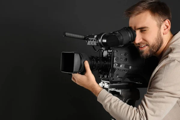 Operatore con videocamera professionale su sfondo nero — Foto Stock