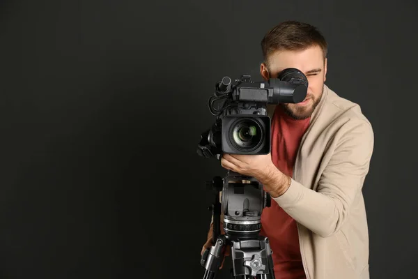 Operador com câmera de vídeo profissional em fundo preto, spa — Fotografia de Stock