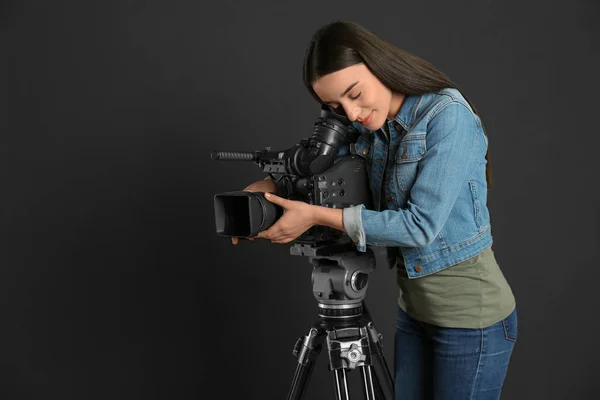 Siyah arkaplanda profesyonel video kamerası olan operatör — Stok fotoğraf