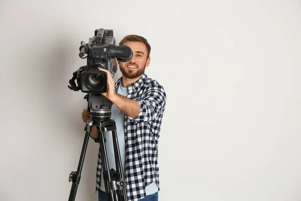 Bediener mit professioneller Videokamera auf weißem Hintergrund, Wellness — Stockfoto