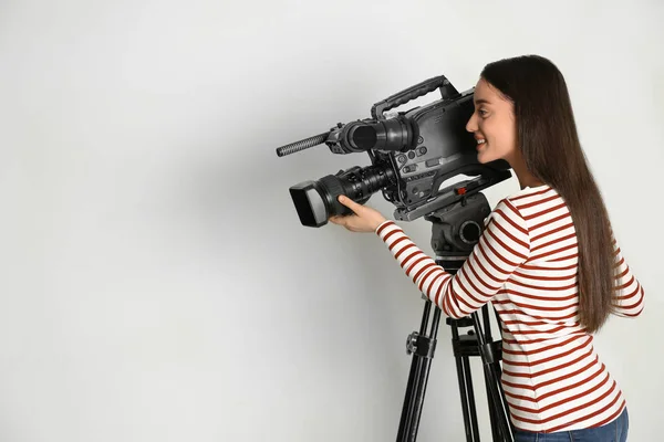 Operador com câmera de vídeo profissional no fundo branco, spa — Fotografia de Stock