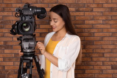 Duvarın yanında profesyonel video kamerası olan bir operatör