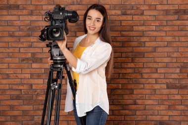 Tuğla duvarın yanında profesyonel video kamerası olan operatör, boşluk f