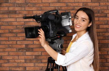 Duvarın yanında profesyonel video kamerası olan bir operatör