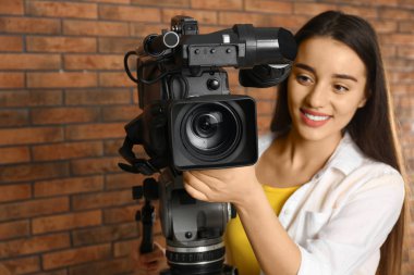 Duvarın yanında profesyonel video kamerası olan bir operatör