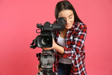 Pembe arka planda profesyonel video kamerası olan operatör
