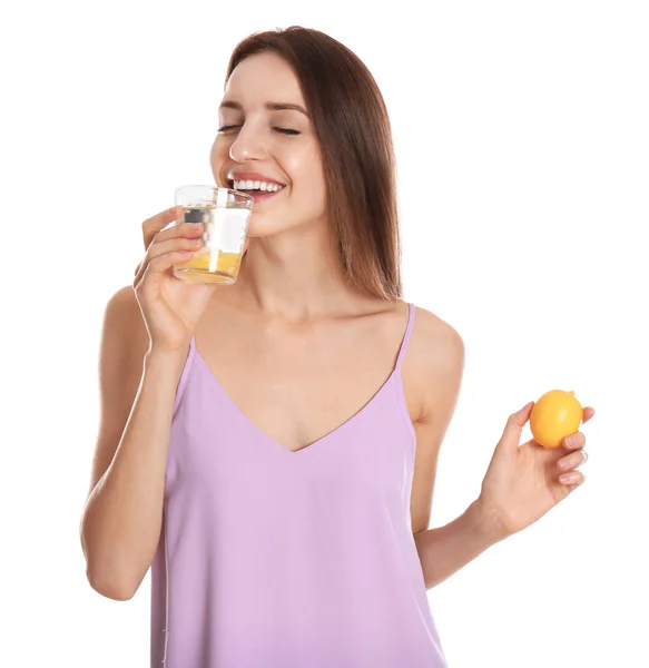 Jonge vrouw drinken citroen water op witte achtergrond — Stockfoto
