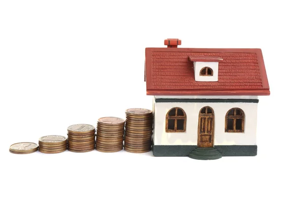Modelo de casa e moedas isoladas em branco — Fotografia de Stock
