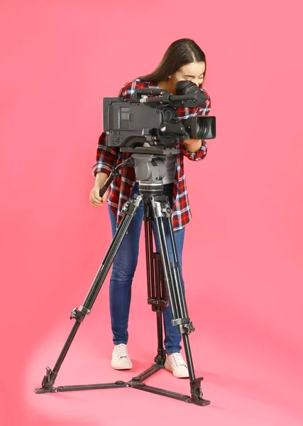 Pembe arka planda profesyonel video kamerası olan operatör — Stok fotoğraf