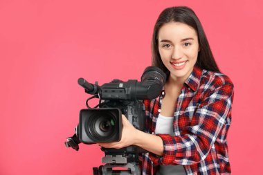 Pembe arka planda profesyonel video kamerası olan operatör
