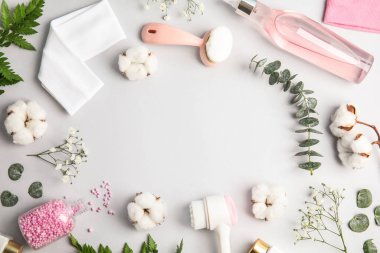 Açık gri arka planda yüz temizleyici fırçalarla düz kompozisyon. Kozmetik aksesuarlar