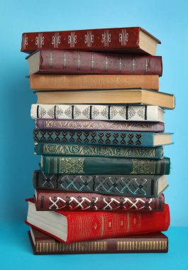 Açık mavi arkaplan üzerine kitap yığını