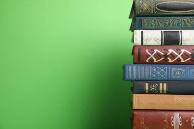 Yeşil arka plan üzerine bir yığın ciltli kitap. Metin için boşluk