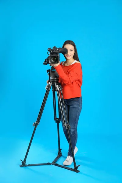 Mavi arkaplanda profesyonel video kamerası olan operatör — Stok fotoğraf