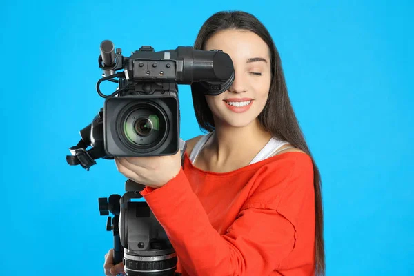 Exploitant met professionele videocamera op blauwe achtergrond — Stockfoto