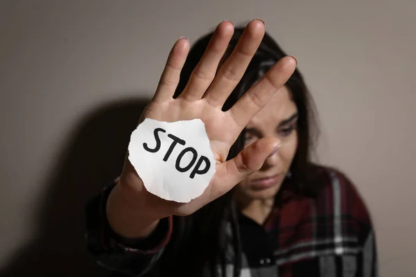 Mishandelde Jonge Vrouw Met Bord Stop Bij Beige Muur Focus — Stockfoto