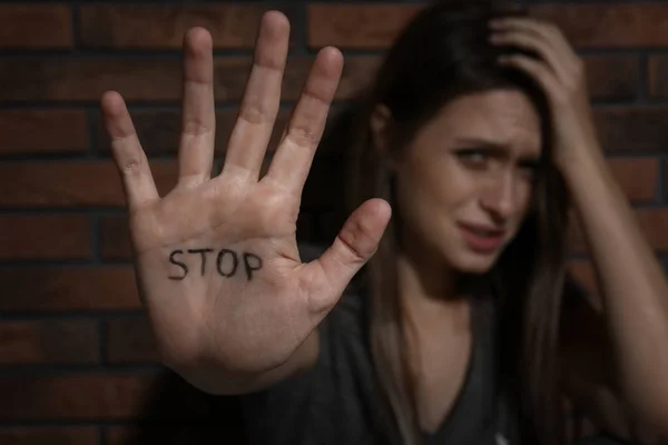 Mujer Joven Maltratada Mostrando Palma Con Palabra Detener Cerca Pared —  Fotos de Stock