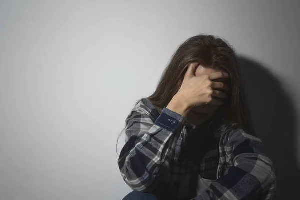 Zneužívaná mladá žena pláče u bílé zdi, prostor pro text. Domy — Stock fotografie