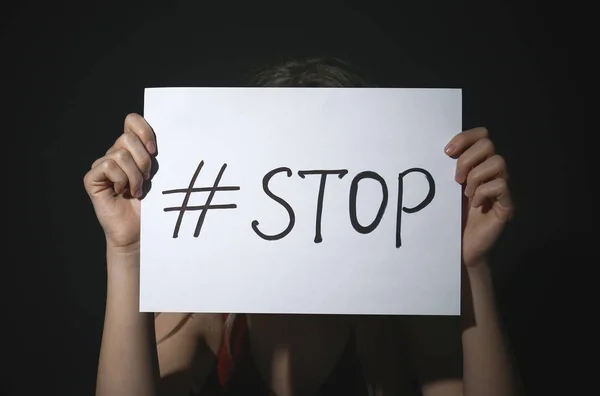 Mujer joven con hashtag STOP sobre fondo negro. Viol doméstico —  Fotos de Stock