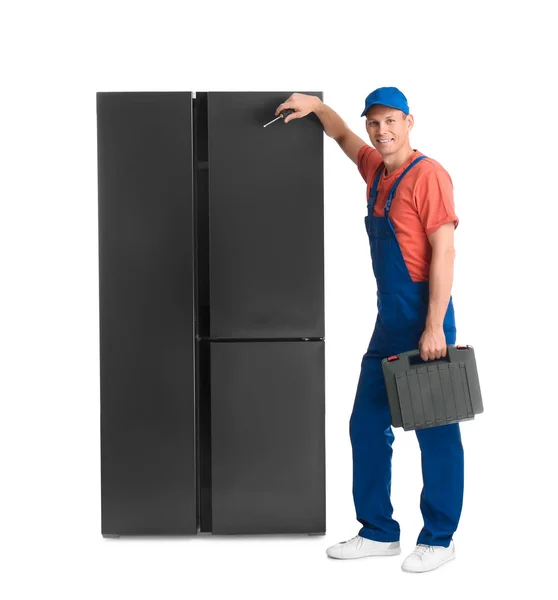 白い背景に冷蔵庫の近くのツールボックスを持つ男性技術者 — ストック写真
