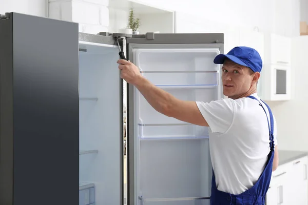 Techniker mit Schraubenzieher repariert Kühlschrank in Küche — Stockfoto