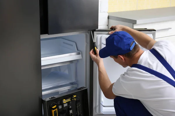 Manlig Tekniker Med Skruvmejsel Reparera Kylskåp Köket — Stockfoto