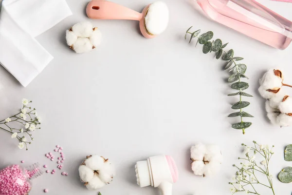 Flat lay composition with face cleansing brushes on light grey background. Cosmetic accessories