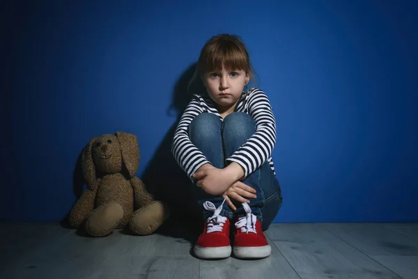 Надругалась над маленькой девочкой с игрушкой у голубой стены. Домашнее насилие — стоковое фото