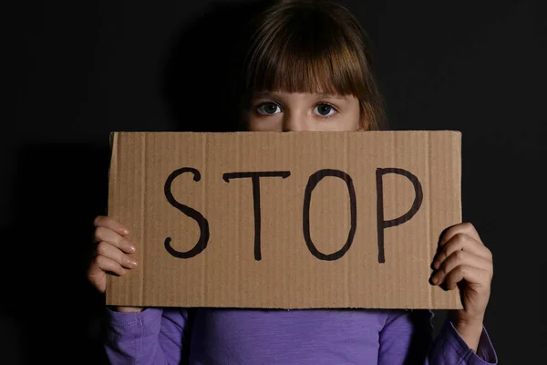 Misshandeltes kleines Mädchen mit Haltezeichen nahe schwarzer Wand. Einheimische Gambe — Stockfoto