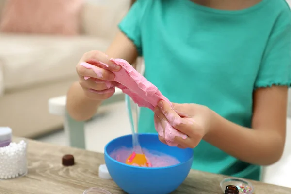 小女孩在屋里的桌子边做Diy黏液玩具 — 图库照片