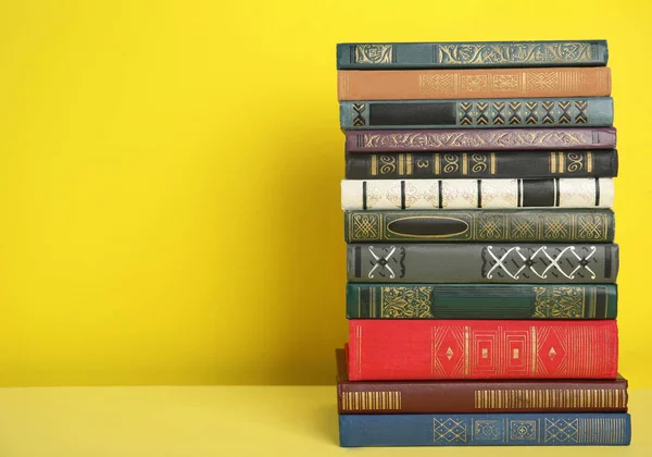 Pilha de livros de capa dura sobre fundo amarelo. Espaço para texto — Fotografia de Stock