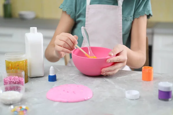 小女孩在厨房的桌子边做自制的黏液玩具 特写镜头 — 图库照片