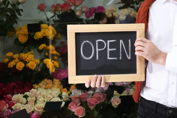 Propietario de un negocio masculino sosteniendo el cartel OPEN en su floristería, closeu — Foto de Stock