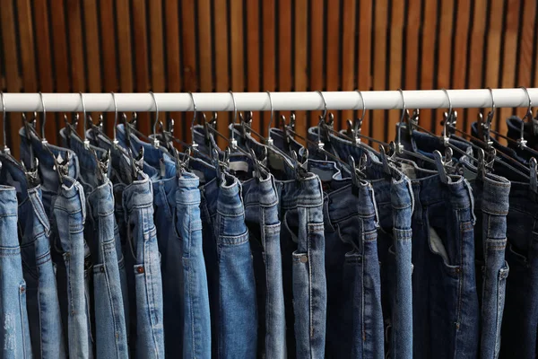 Support avec différents jeans sur fond en bois — Photo