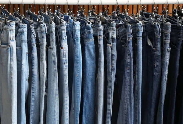 Support avec différents jeans sur fond en bois — Photo