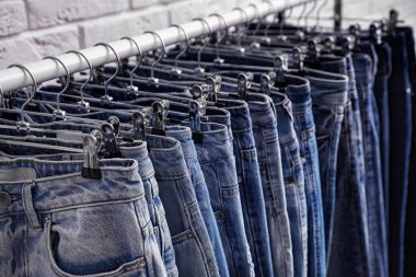 Tuğla duvarın yanında şık kotlu raflar, yakın plan.