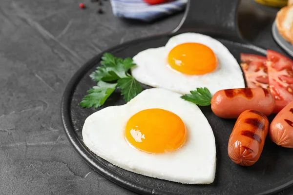 Leckeres Frühstück Mit Herzförmigen Spiegeleiern Und Würstchen Auf Dunkelgrauem Tisch — Stockfoto