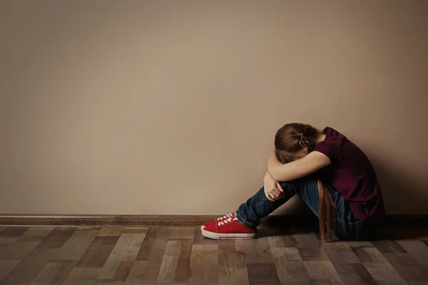 Девочка на полу в помещении, место для смс. Ребенок в опасности — стоковое фото