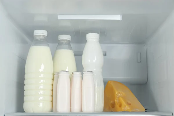Bottles of dairy products on shelf in refrigerator