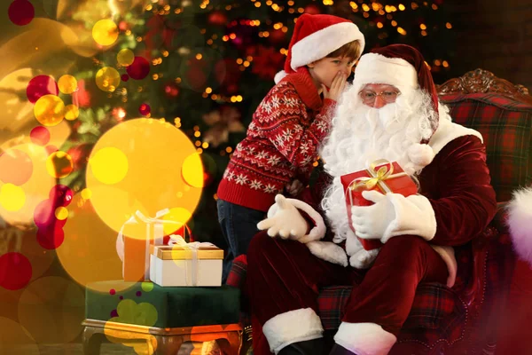 Santa Claus y el niño pequeño cerca del árbol de Navidad en el interior — Foto de Stock